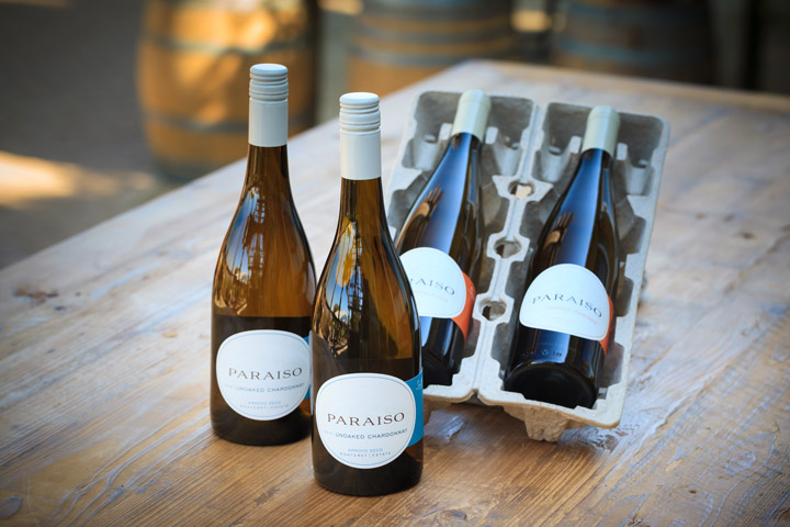 Bottles from wine club shipment on table with shipping box.